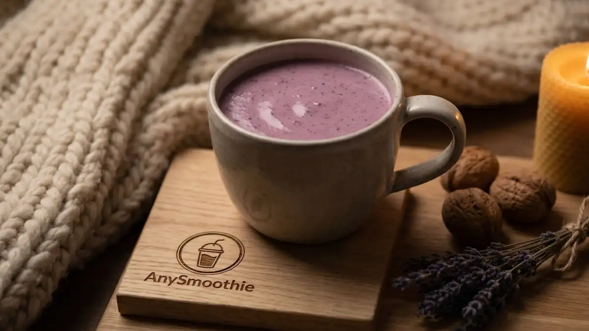A cozy soft-purple smoothie in a ceramic mug on an AnySmoothie oak coaster, surrounded by walnuts, dried lavender, and a soft blanket under warm candle-like lighting.