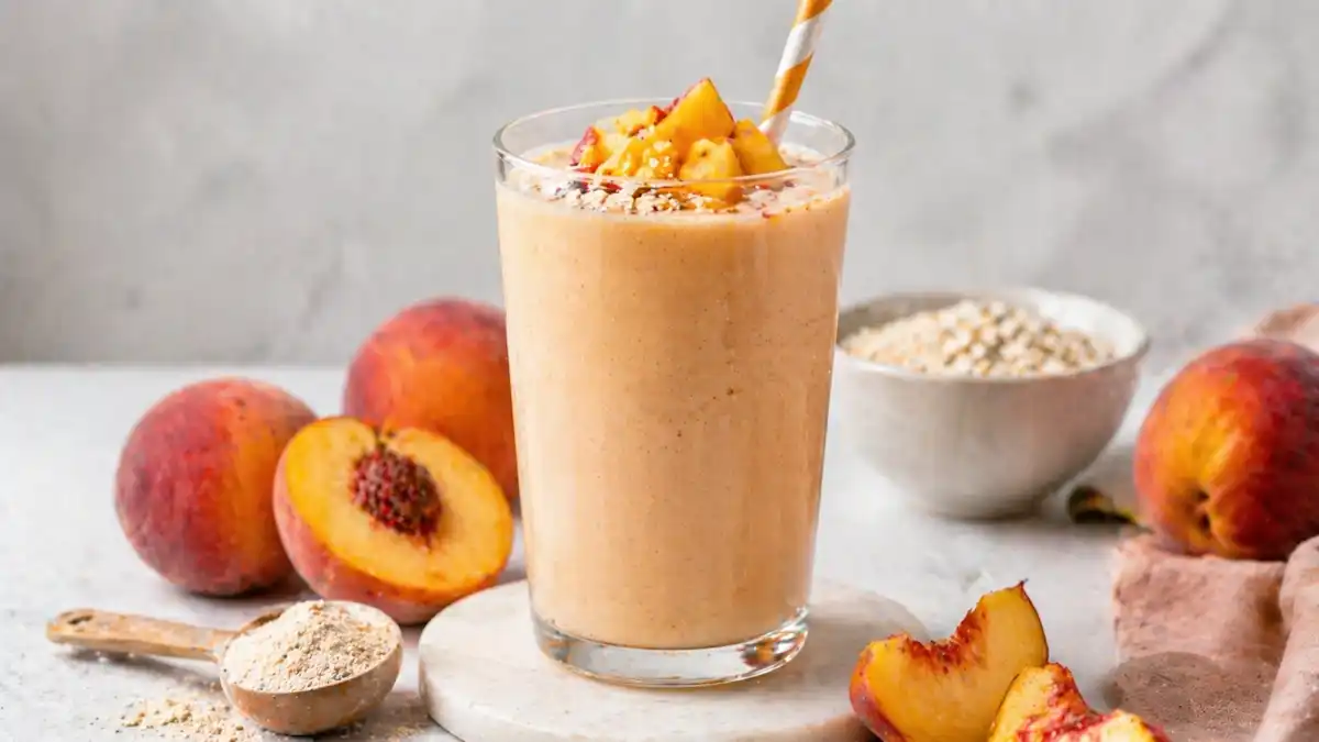 Creamy peach protein shake in a glass made with fresh peaches, healthy high protein smoothie for breakfast or post workout